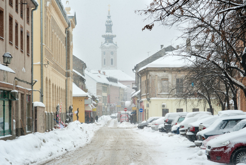 Zdjęcie przedstawiające miejską uliczkę podczas opadów śniegu.