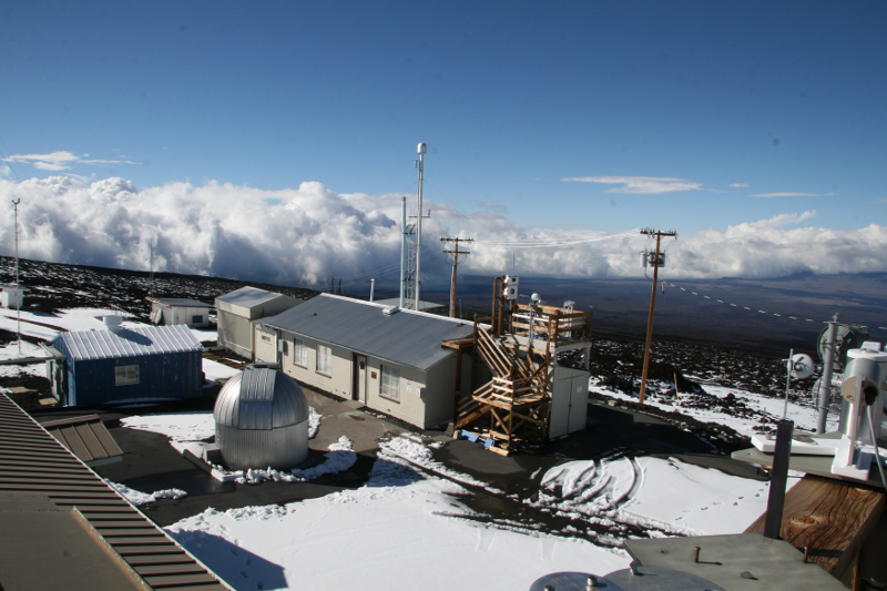 Zdjęcie przedstawia zabudowania i urządzenia na zboczu pokrytej częściowo śniegiem góry.