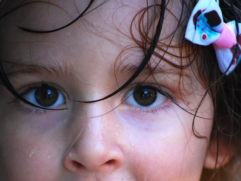 Zdjęcie przedstawia górną część twarzy małeś dziewczynki z widocznymi kroplami potu.