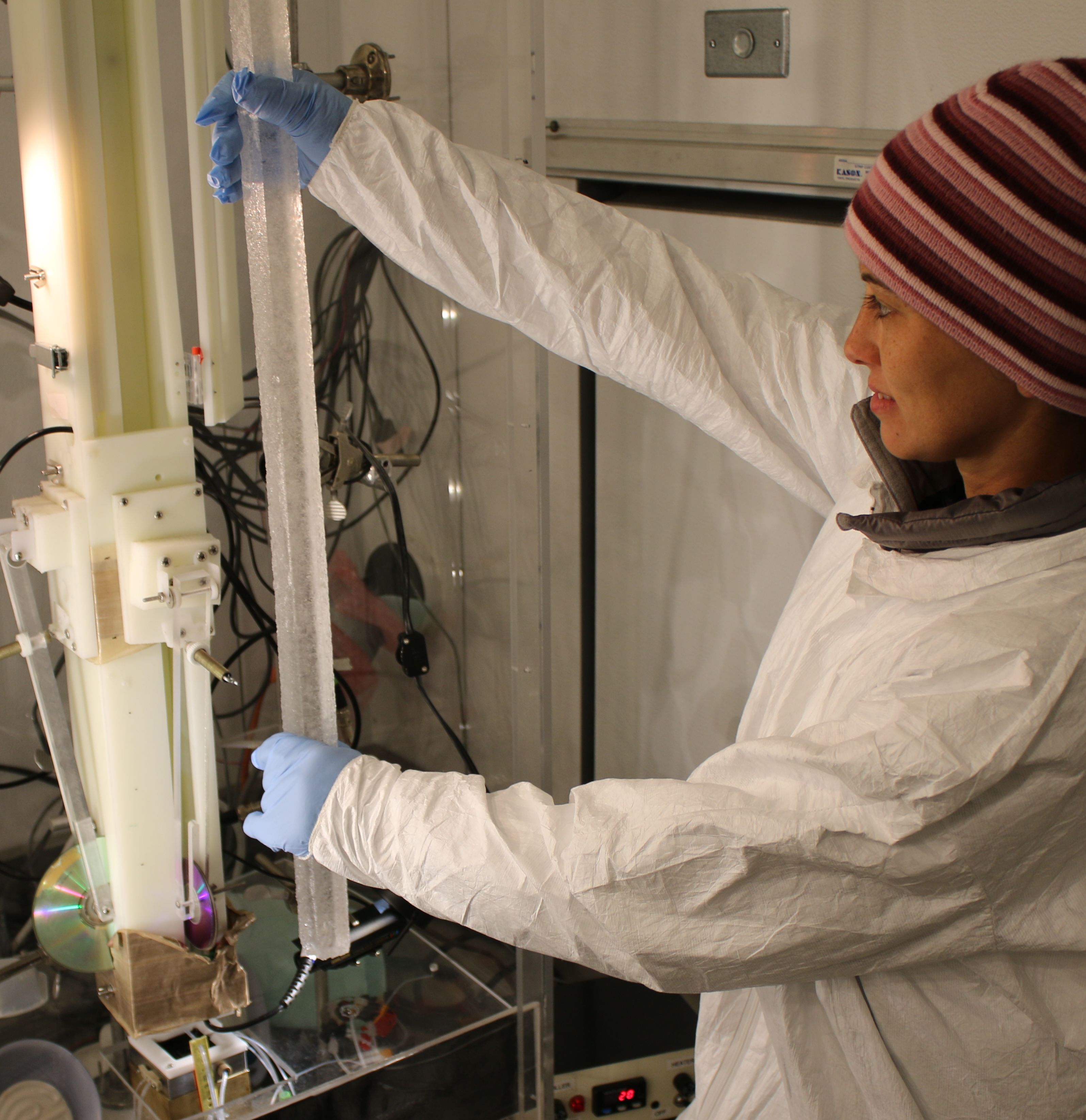 Zdjęcie: badaczka umieszcza rdzeń lodowy w urządzeniu do analizy chemicznej. 