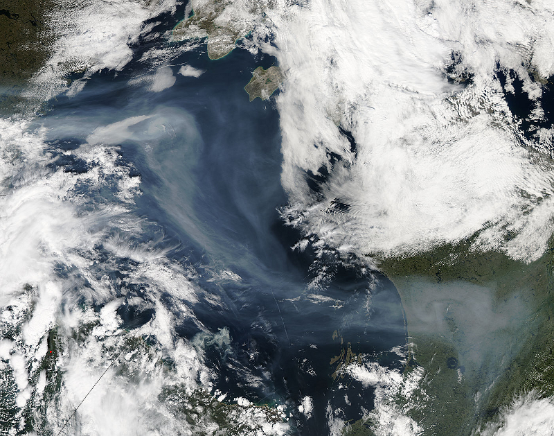 Zdjęcie satelitarne przedstawiające płaty chmur oraz dym widoczny nad powierzchnią wody w zatoce Hudsona.