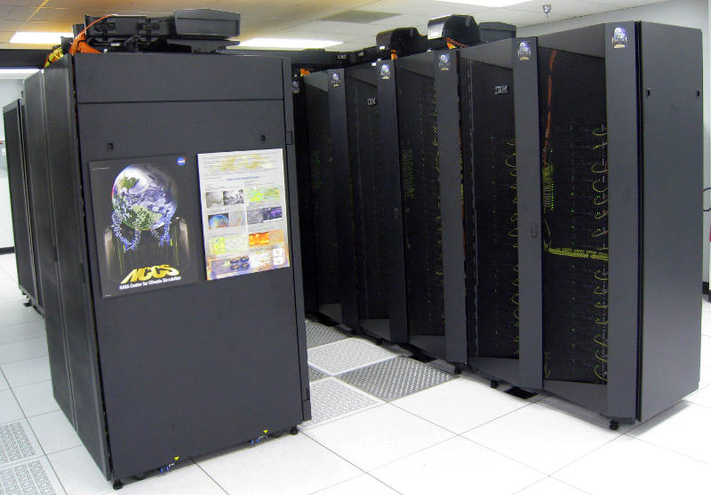 Zdjęcie przedstawia pokój pełen szaf bedących w istocie stelażami wypełnionymi podzespołami superkomputera