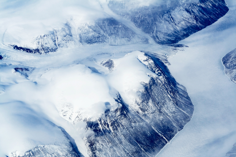 Zdjęcie przestawia niebiesko0biały krajobraz Grenlandii z widocznymi jęzorami lodowca.