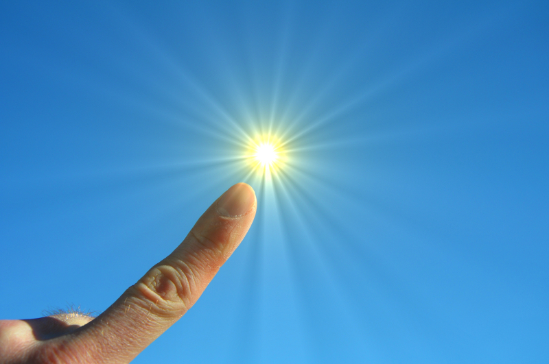 Zdjęcie przedstawia tarczę słoneczną, na którą wskazuje palec