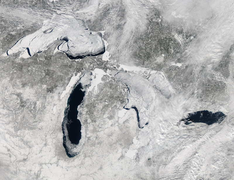 Zdjęcie satelitarne przedstawiające zaśnieżoną powierzchnię Ameryki wraz z pokrytymi lodem jeziorami