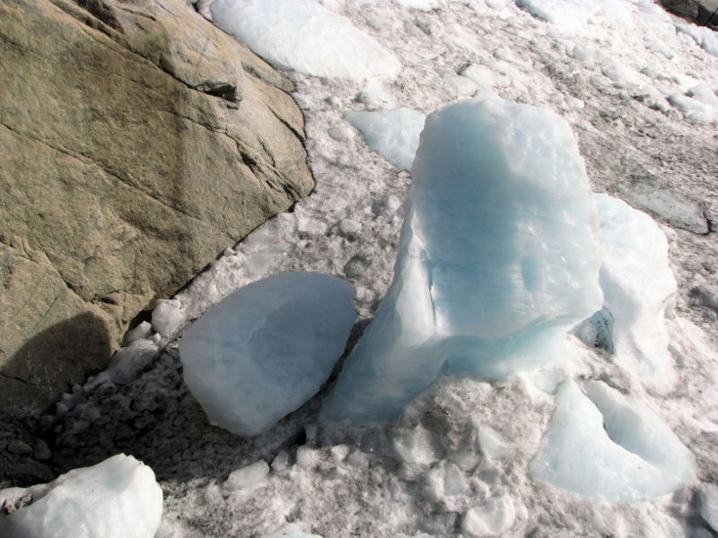 Zdjęcie przedstawia lodowy ostaniec wystający ponad poczernioną sadzą powierzchnią lodowca