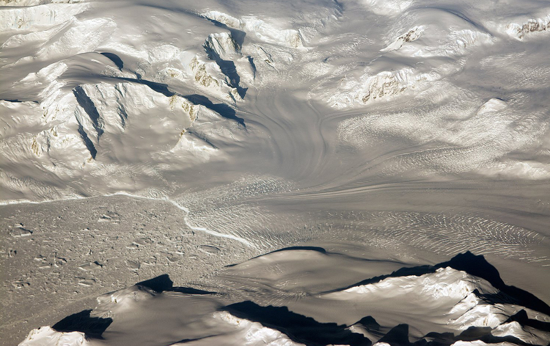 Zdjęcie przedstawia krajobraz Antarktydy: biało szare wzgórza i doliny