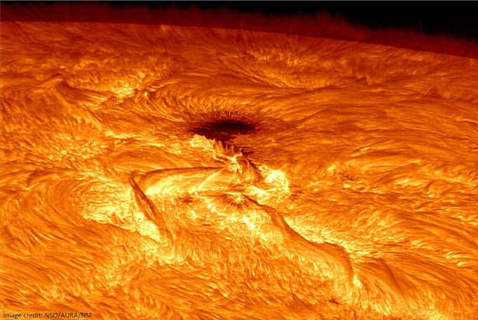 Wycinek powierzchni Słońca. Widoczna jest grupa plam słonecznych oraz poświata nad powierzchnią.