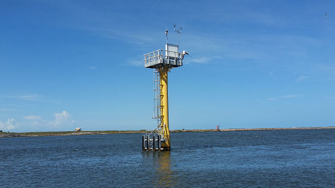 Stacja pomiarów poziomu morza i pogody. Na wysokim, żółtym słupie wbitym w dno morza i wystającym dużo powyżej zainstalowana jest platforma pomiarowa z instrumentami.