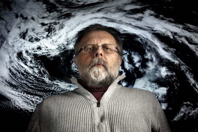 Zdjęcie: prof. Szymon Malinowski, portret na tle satelitarnego zdjęcia cyklonu