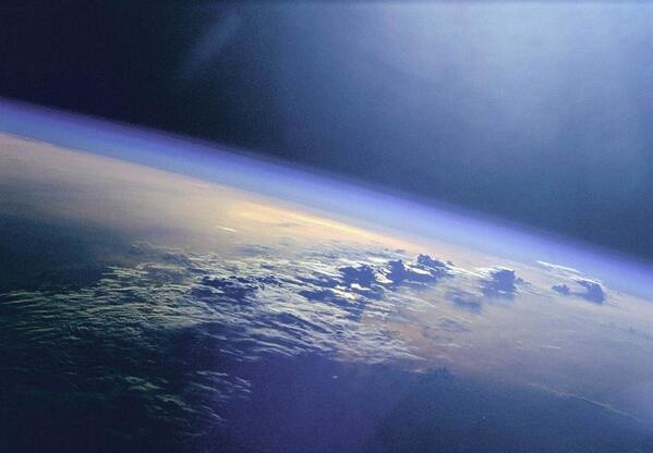 Zdjęcie pokazujące fragment Ziemi, z widoczną nad nim cienką warstwą atmosfery.