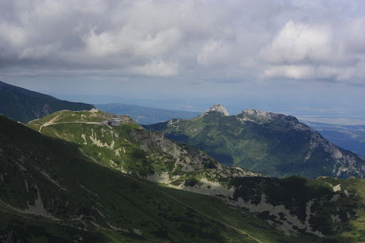 Zdjęcie: Kasprowy Wierch i Giewont. Górski krajobraz z dwoma szczytami, pora letnia, niskie chmury.