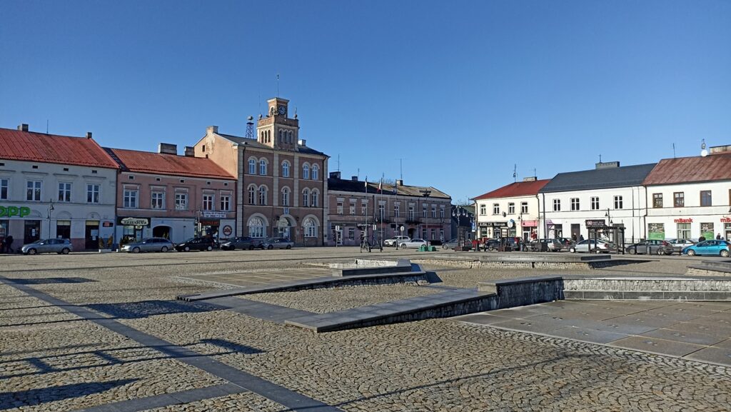 Betonoza. Rynek w Skierniewicach - rozległy pusty plac pokryty kostką brukową i płytami chodnikowymi. 