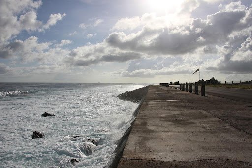 Zdjęcie przedstawia fale oceanu, które obmywają pas startowy na wyspie Naru.