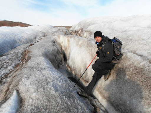 Zdjęcie przedstawia autora artykułu stojącego pomiędzy spękaniami lodowca górskiego.