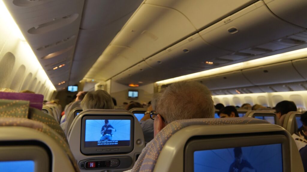 Zdjęcie: wnętrze samolotu pasażerskiego wypełnionego pasażerami. 
