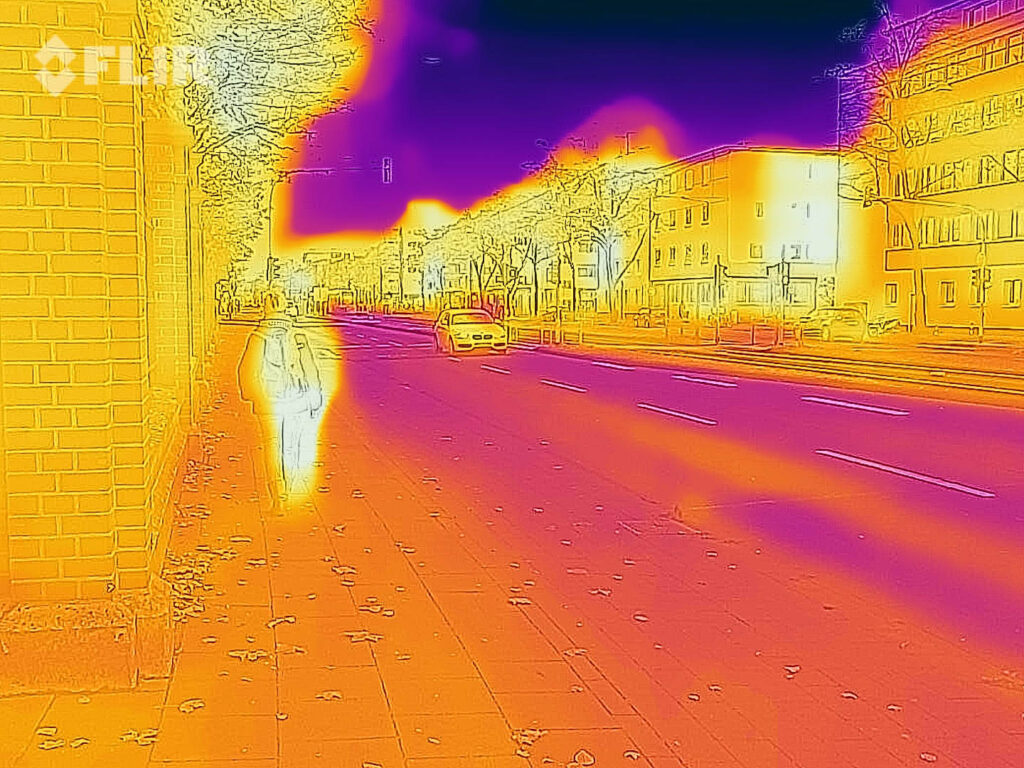 Miejsca wyspa ciepła: zdjęcie ulicy w podczerwieni, widać, że budynki i samochód są cieplejsze od podłoża i nieba.