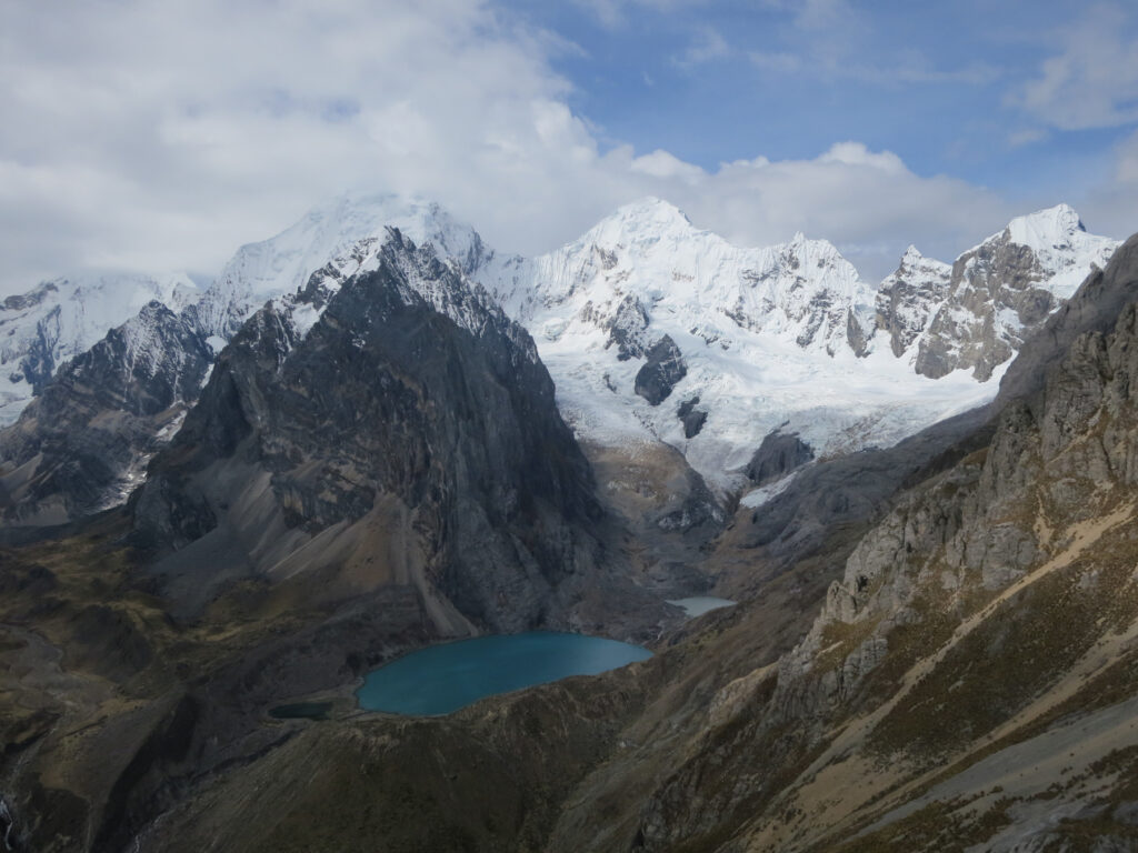 Zdjęcie przedstawia łańcuch górski, szczyty pokryte są lodem, w dolinie widać jezioro.