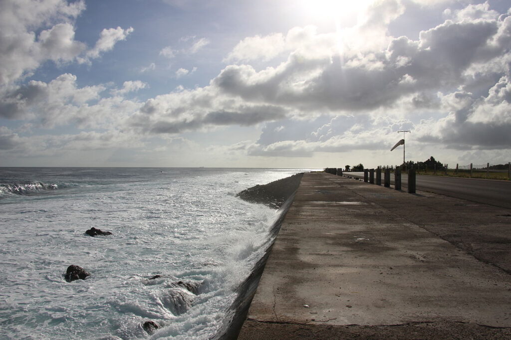 Zdjęcie przedstawia fale oceanu, które obmywają pas startowy na wyspie Naru.