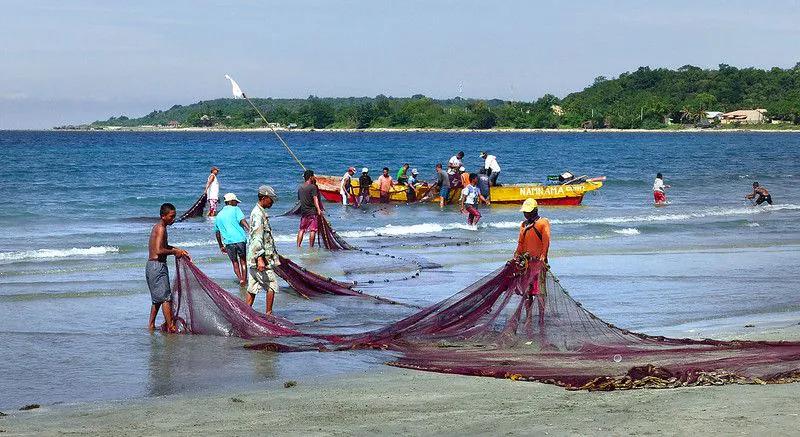 Zdjęcie: Filipiny: rybacy po połowie rozkładają sieci na brzegu morza.