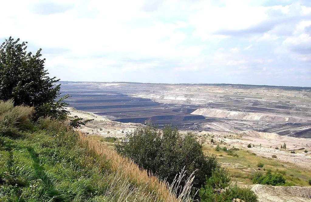 Zdjęcie: kopalnia odkrywkowa w Bełchatowie. Rozległy obszar wzgórków i zagłębień o geometrycznych kształtach.