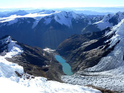 Zdjęcei przedstawia lodowce górskie. W dolinie widać jezioro typu GLOF.