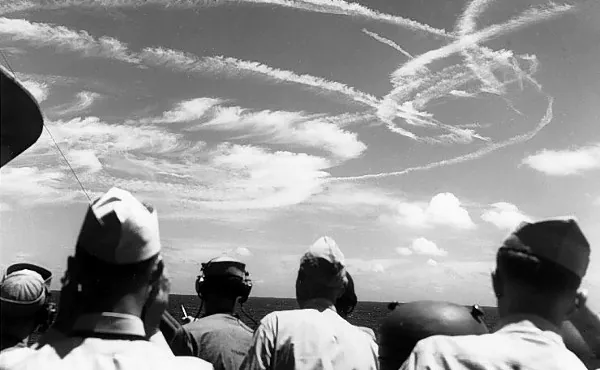 Lotnictwo a chmury: czarno-białe zdjęcie grupy marynarzy patrzących na smugi kondensacyjne. 