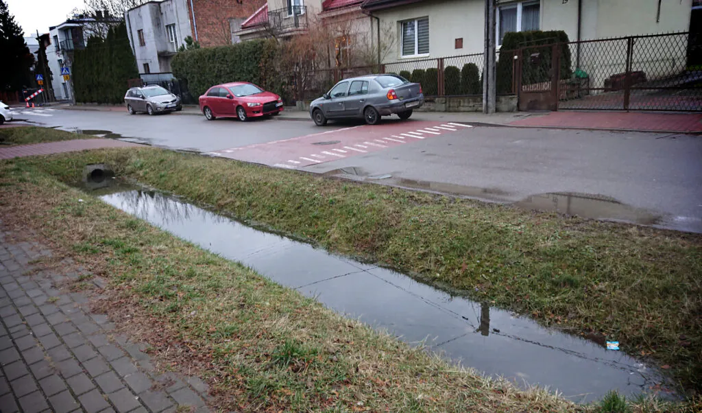 Zdjęcie: rów z wodą wzdłuż ulicy. 