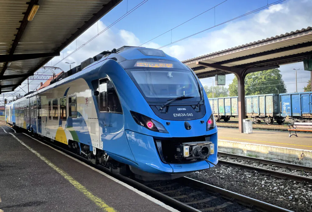 Zdjęcie dekoracyjne: nowoczesny pociąg na niewielkiej stacji. Infrastruktura transportowa, kolej. 
